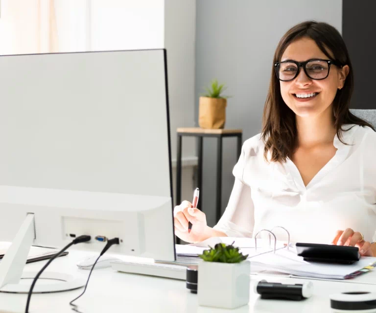 Uśmiechnięta kobieta pracująca przy komputerze